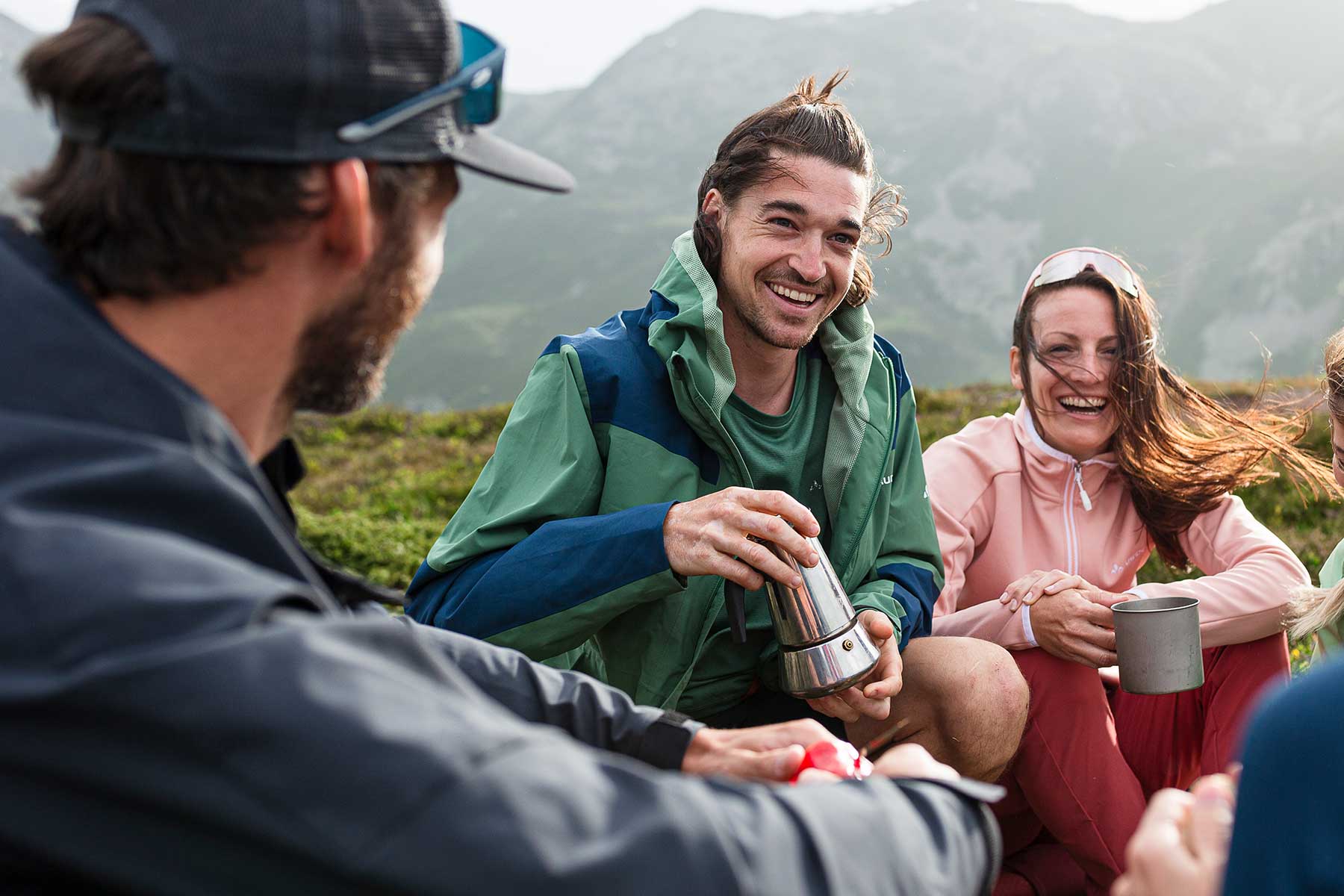 Three people in front of a mountain massif